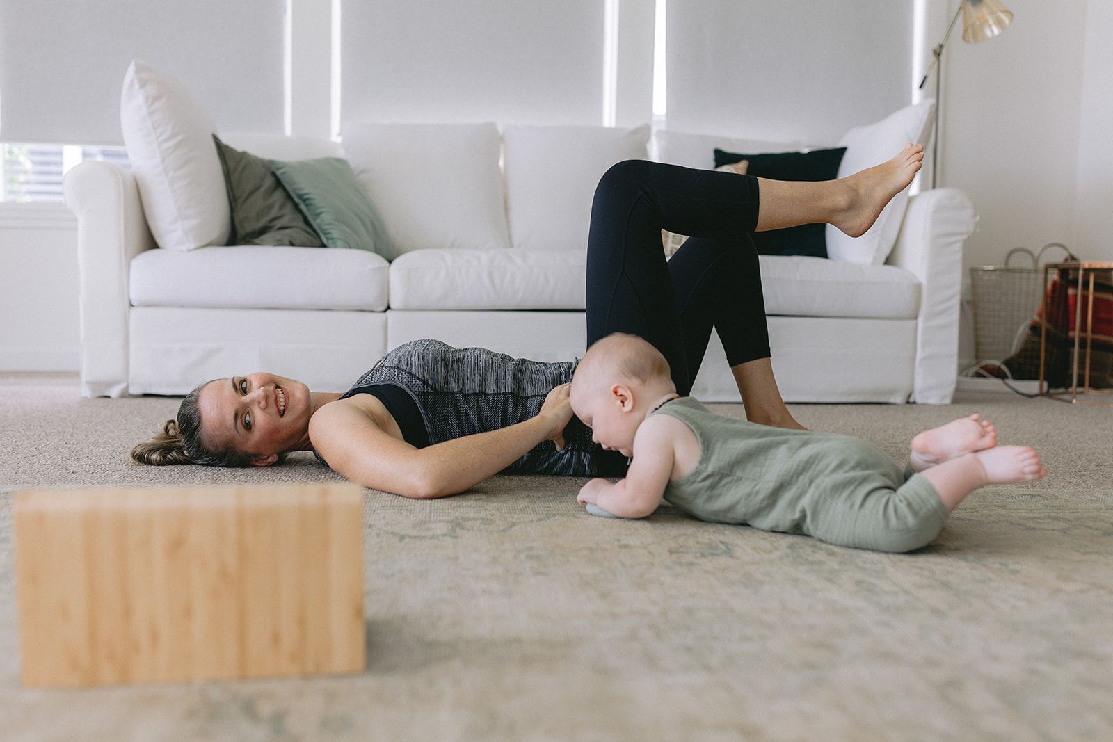 Woman doing Pilates at home on the floor with her baby